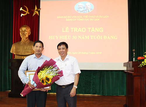 Đồng chí Phùng Minh Cường - Phó Bí thư thường trực Đảng ủy Bộ VHTTDL trao Huy hiệu 30 năm tuổi Đảng cho đồng chí Lê Tuấn Anh
